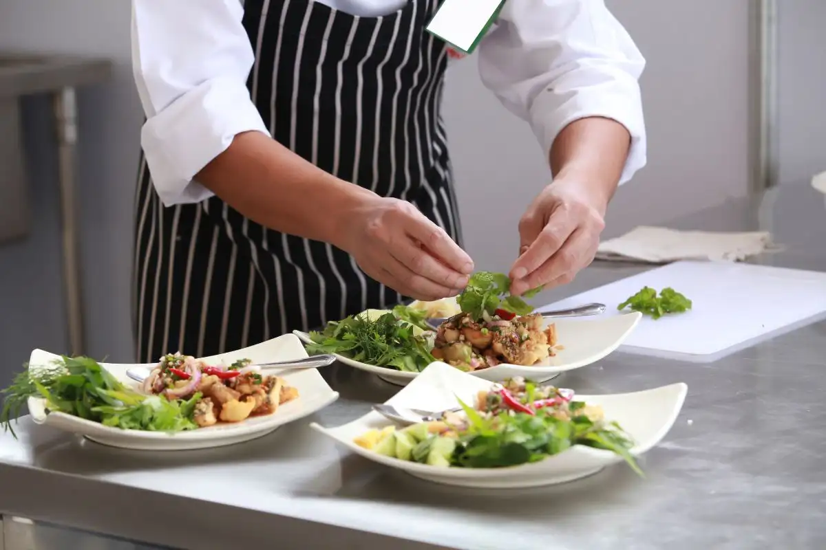 cocinero profesional dando los últimos toques a un plato